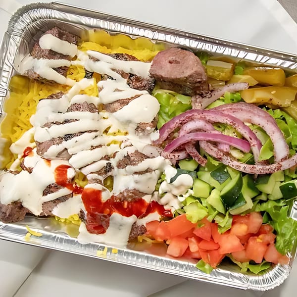Halal Bros platter with meat, rice, salad, and sauces in a foil container.