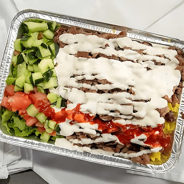 Halal Bros' chicken and lamb over rice with white and red sauce, and a side salad.
